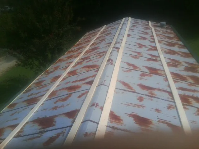 Rusted metal roof panels with new wood purlins before replacement — Storm Damage Roof Repair in Dola by Roofing Brothers